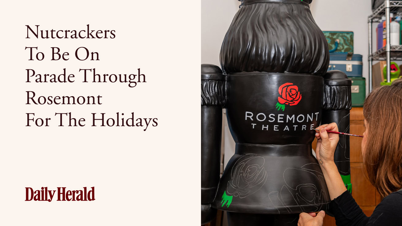 A person paints a red rose design on the back of a large black nutcracker statue, marked Rosemont Theater, with text on the left from the Daily Herald: "Nutcrackers To Be On Parade Through Rosemont For The Holidays."