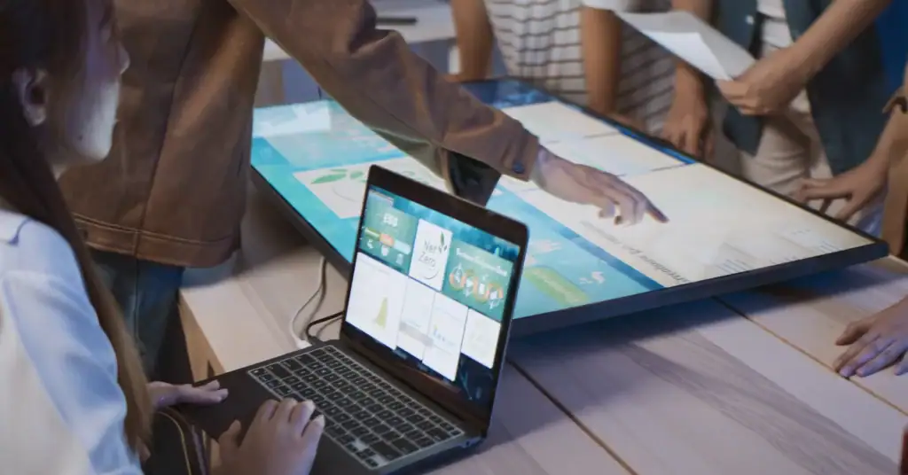 A group of people working together and examining a screen.