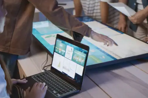A group of people working together and examining a screen.