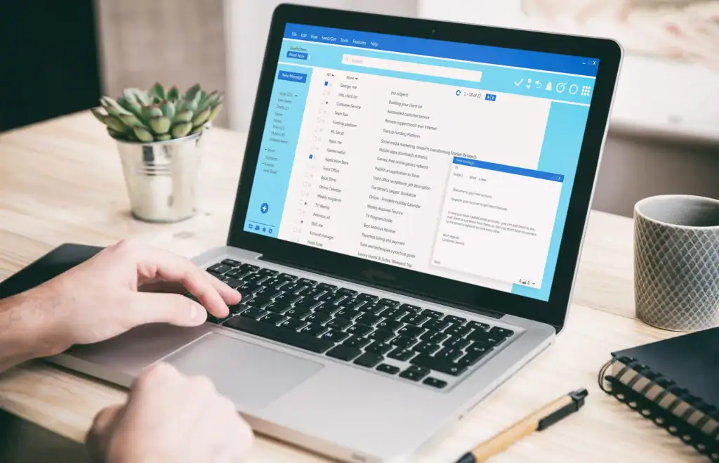 A person writing an email on their laptop.
