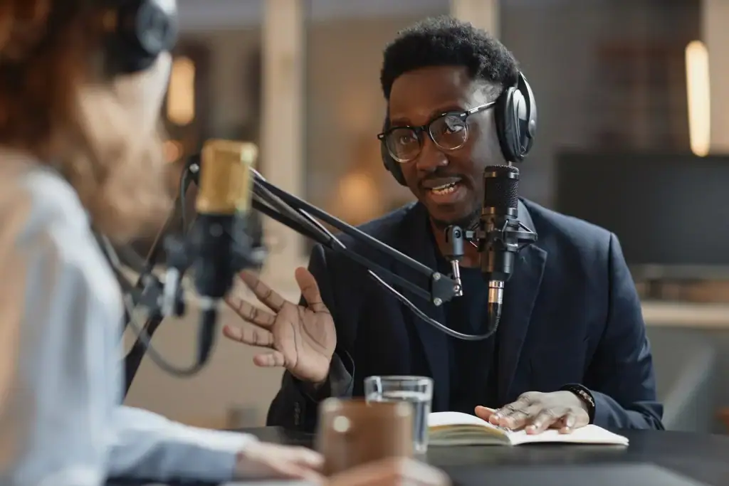 Two people speaking with microphones.