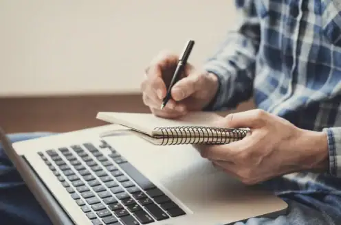 A person taking notes in a notebook.