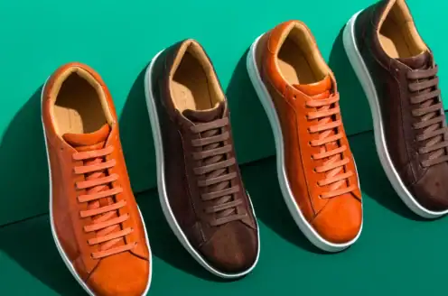 Three pairs of brown, orange and black sneakers.
